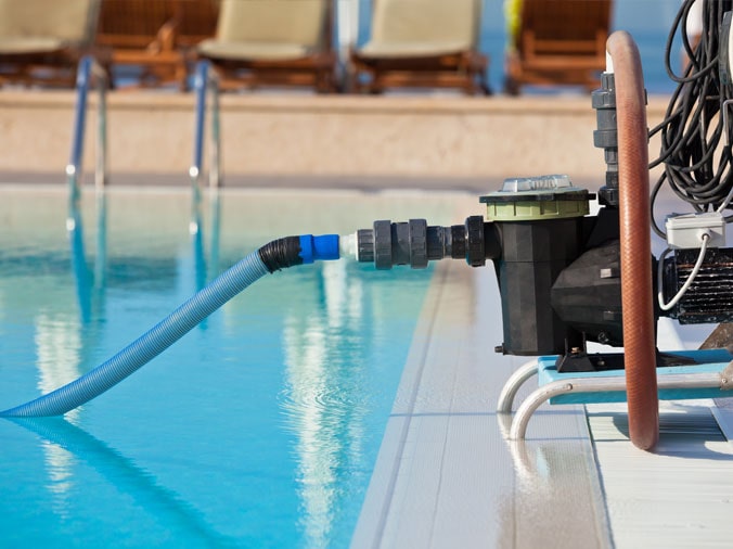 Pool vacuum hooked up on the side of a private pool